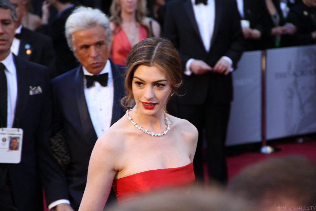 Anne Hathaway en una alfombra roja con un vestido rojo