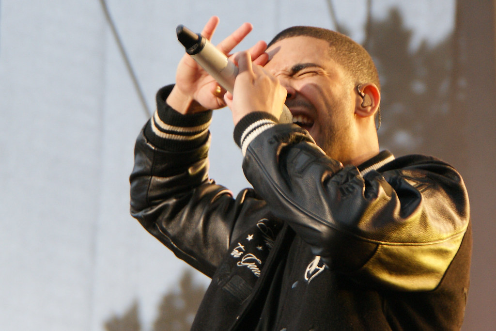Drake cantando sobre el escenario con un micrófono