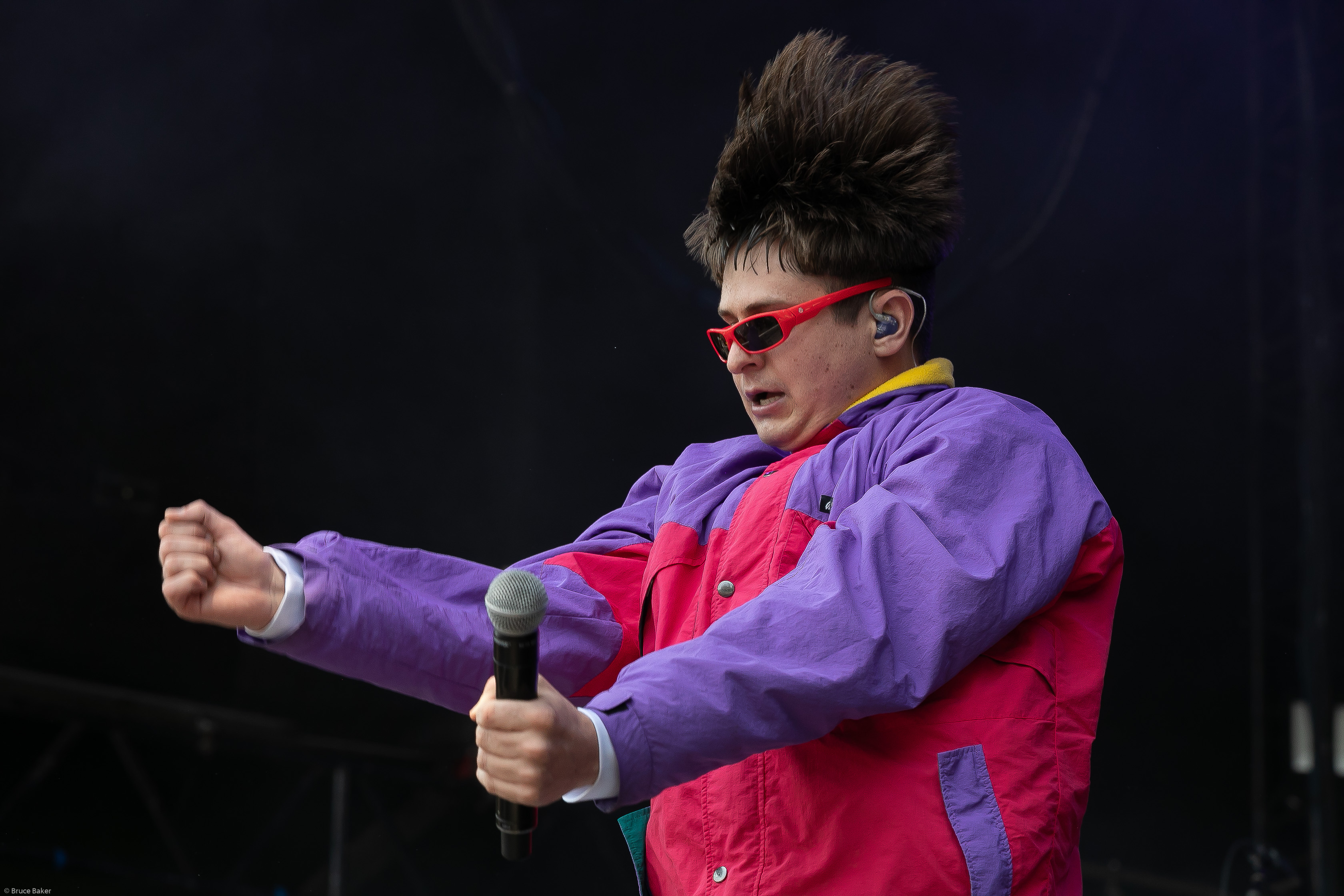 Oliver Tree sobre el escenario con gafas de sol rojas y un micrófono