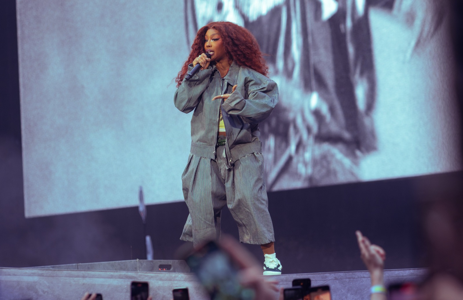 SZA cantando sobre el escenario con un micrófono