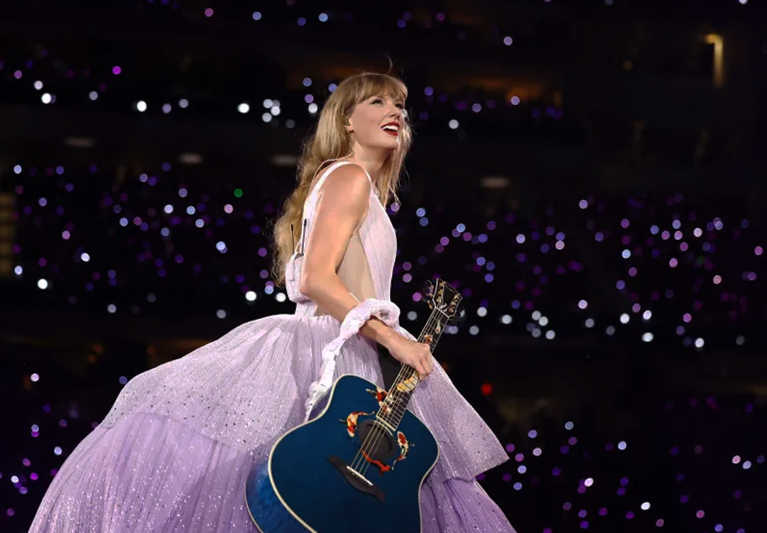 Taylor Swift sobre el escenario con una guitarra azul